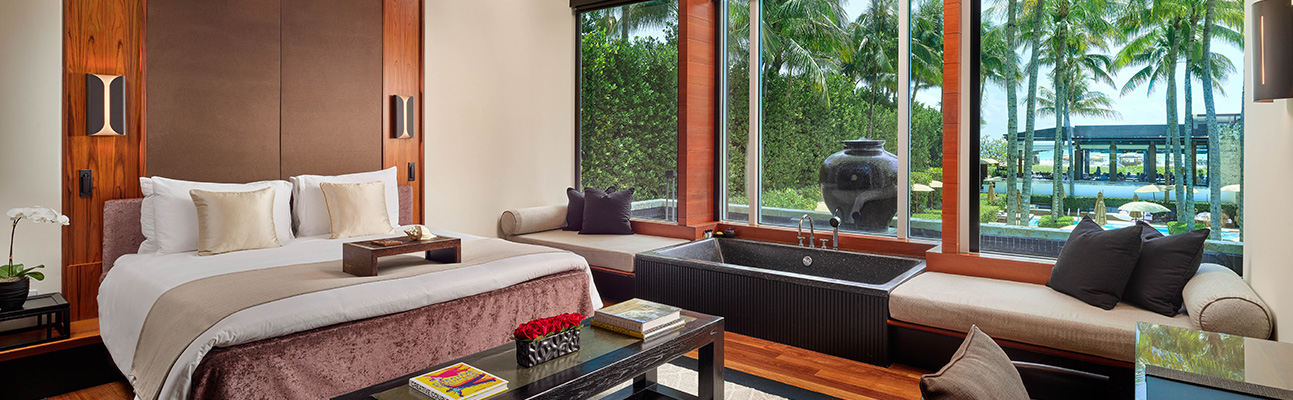 a large room with a view of the garden and palm trees