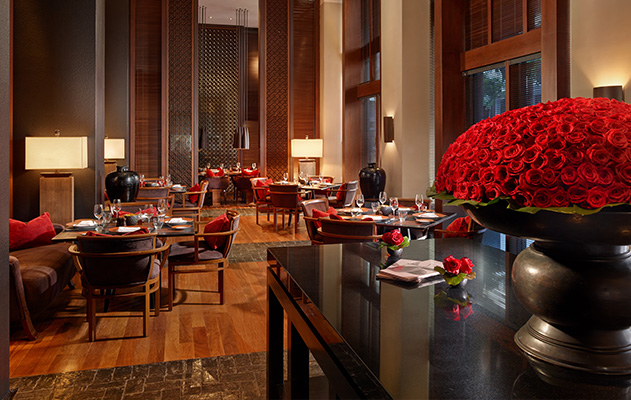 a low lit dining room with red accent pillows and wood trim finishes