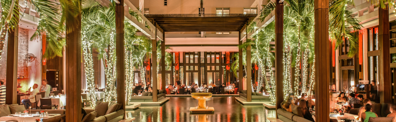 courtyard of hotel with christmas lights on palm trees