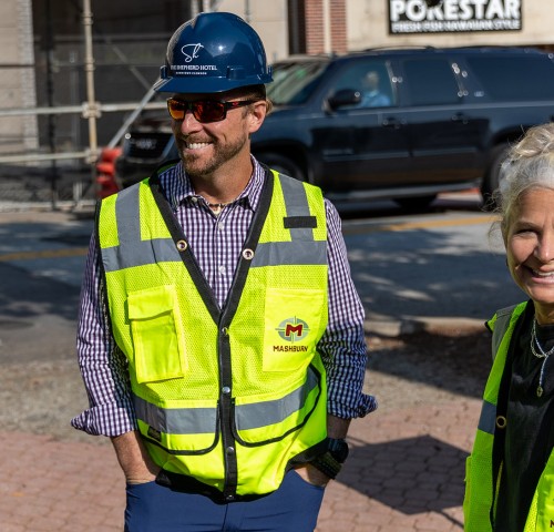 people in construction vests smiling