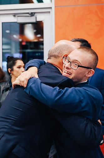 older man and younger man hugging