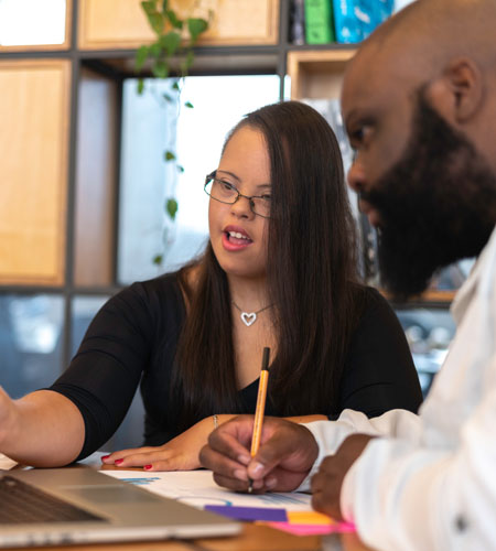 woman explaining something on computer to man