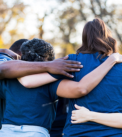 people in blue shirts with arms around each other