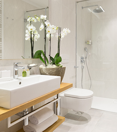 white bathroom with large plant on the counter