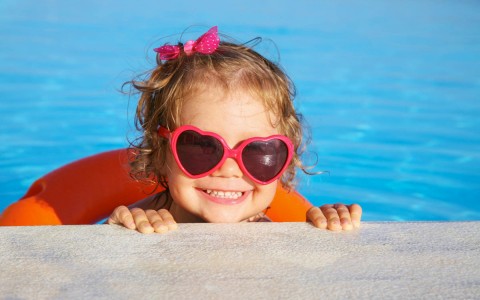 small girl with heart sunglasses in the pool