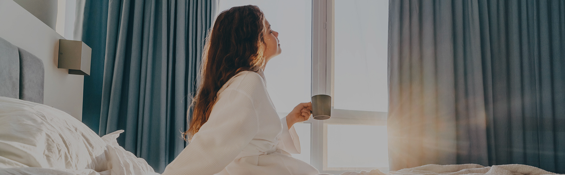 woman enjoying a cup of coffee with a bathrobe 