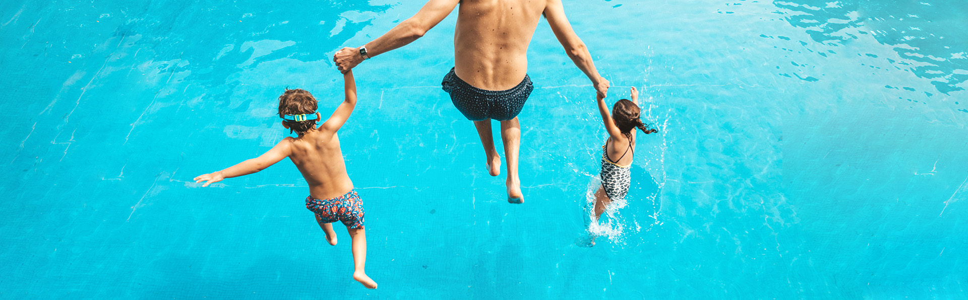 man jumping with kids to a pool