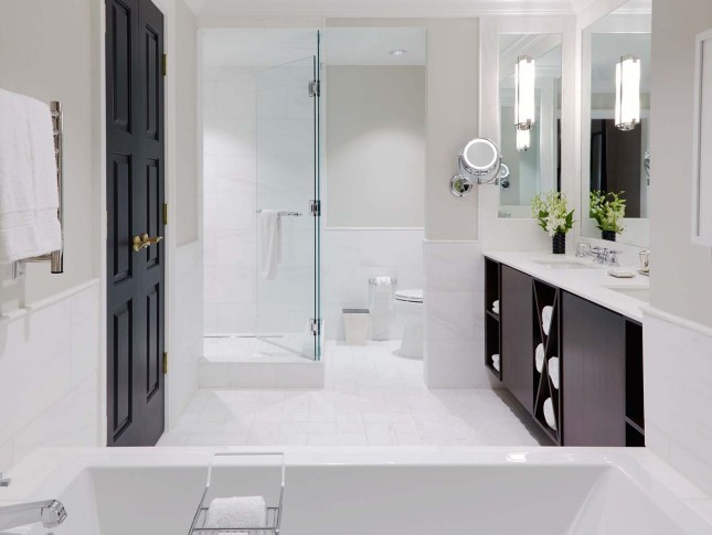 spacious and modish washroom of property with two sinks in white accents