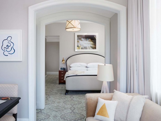 view of a suite room of property in pale accents and features as a queen bed and a sofa
