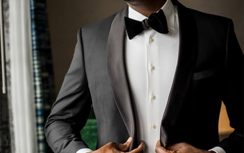 view of a groom adjusting his tuxedo