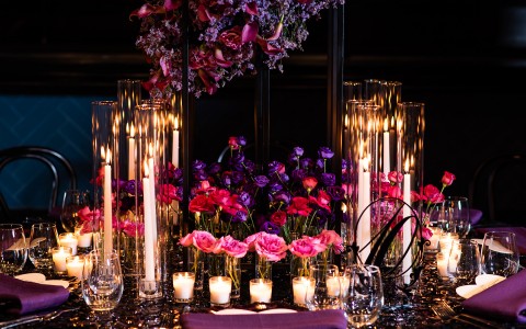 view of a table decorated with colorful flowers and candles