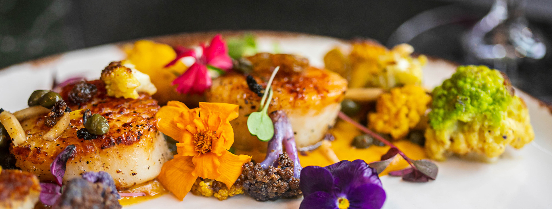 scallops served with broccoli, flowers and orange sauce