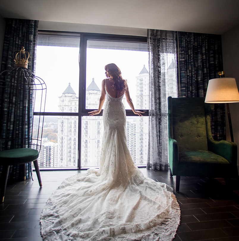 a woman in a wedding dress looking out the window