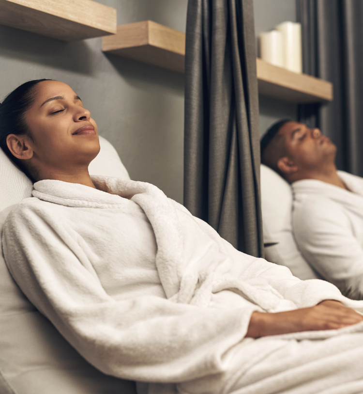Couple wearing white robes while relaxing at a spa