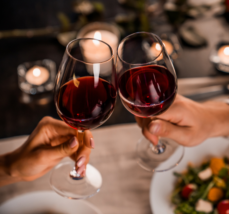 red wine glasses cheersing at dinner