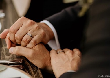 two people holding hands with wedding bands