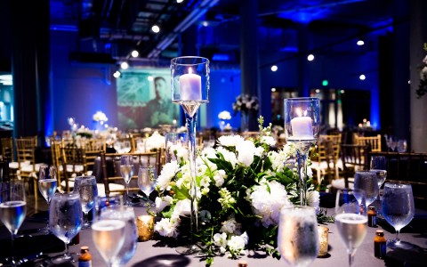 Photo credit to Bambino International, a large open art gallery with round tables set for a wedding reception