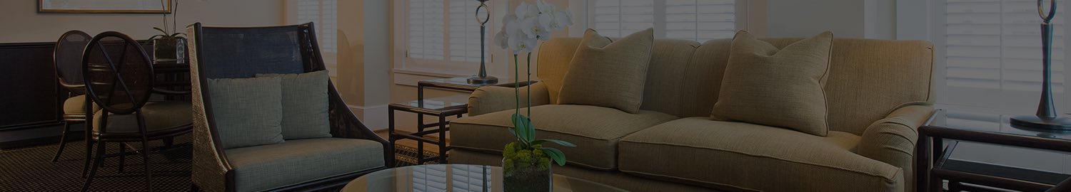 wide header image of lounge seating area with chairs and glass table