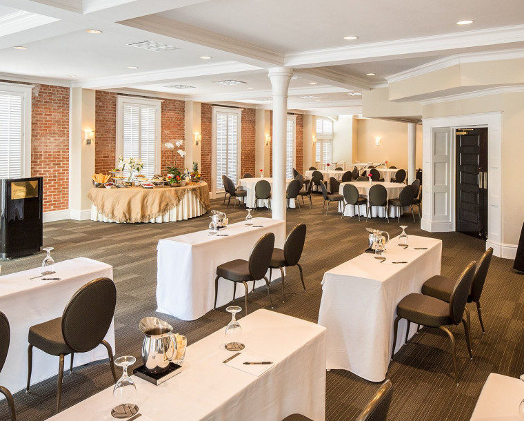 an event space setup with black chairs and white tables