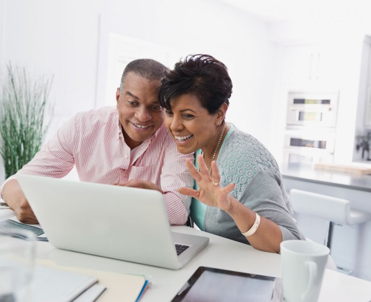 an older couple excited about something on the computer screen