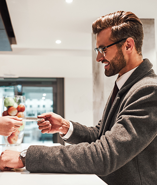 man smiling in the counter receiving a paper