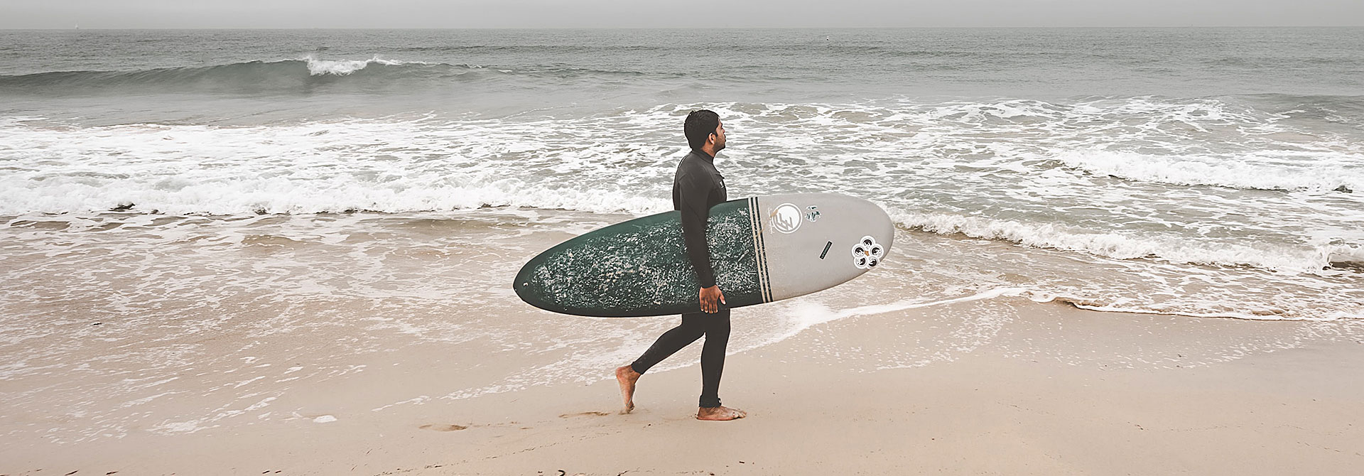 surfer walking on beach