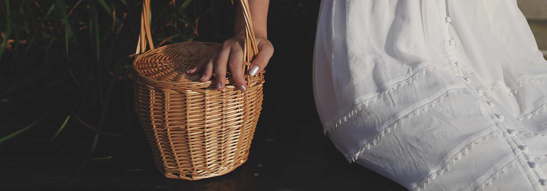 woman in white dress holding a wicker basket