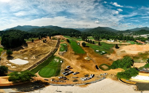aerial view of the golf being built with the mountains in the distance