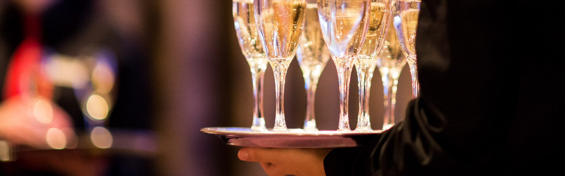 a waiter serving champagne on a tray