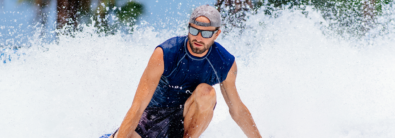 man surfing with splash of water behind