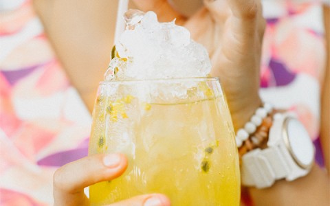 lady holding a yellow cocktail