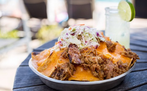 loaded nachos with pulled pork and topped with a cole slaw salad