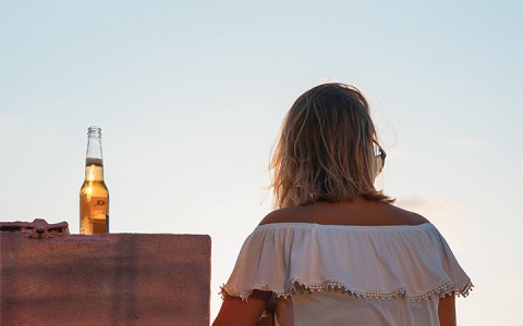 girl enjoying the views with a beer on the side