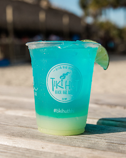 blue cocktail served in a cup with the Tiki Hut logo