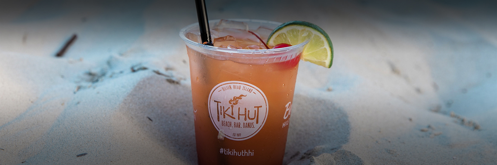 a cocktail sitting in the sand