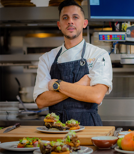 Executive Chef in kitchen with main course