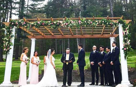 bride and groom up at alter flanked by bridal party