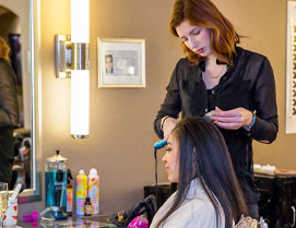 women getting hair curled by hair stylist