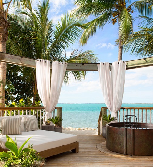 Daybed and jacuzzi on a deck in-front of a beach