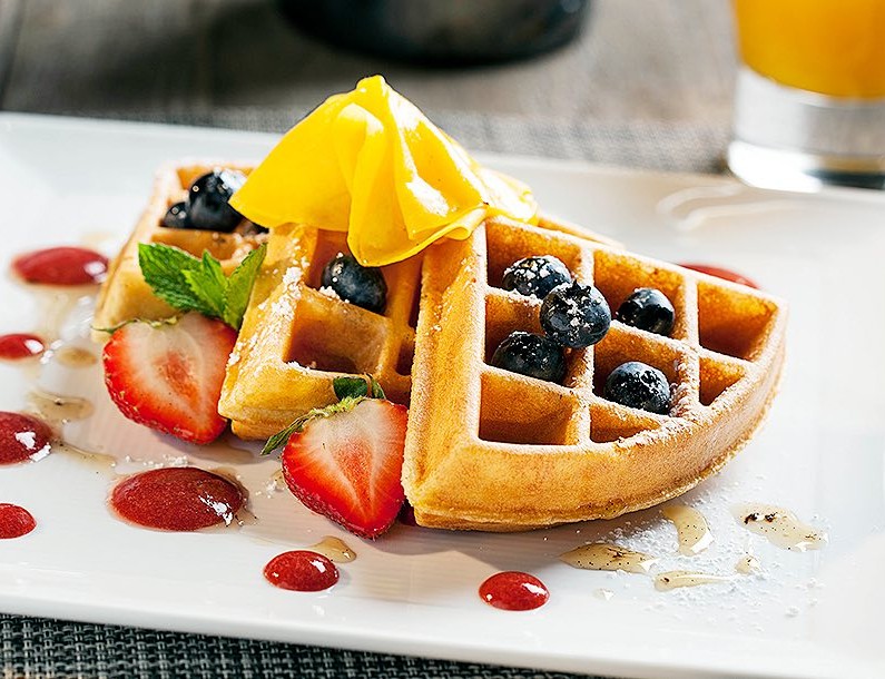 three waffle pieces garnished with fruit
