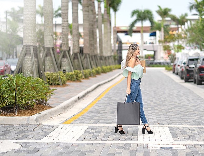 woman with a shopping bag crossing the street