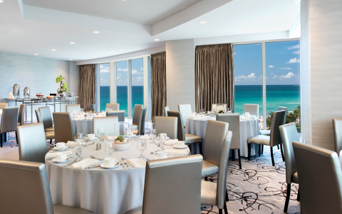  a large room set up for dining overlooking the beach