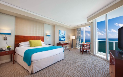 a colorful hotel room with large windows overlooking the ocean