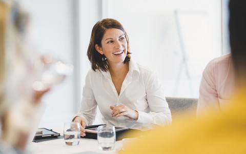 a woman in a meeting speaking with a colleague 