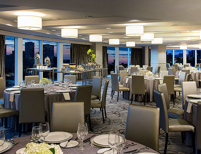  a large room set up for a dinner overlooking the city 
