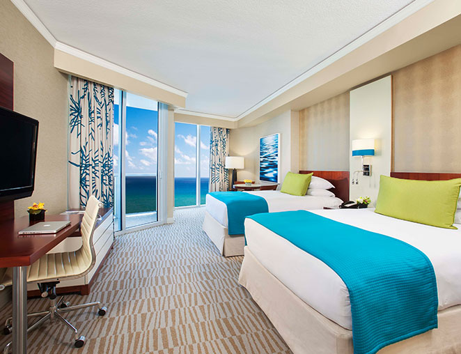 a colorful hotel room with large windows overlooking the ocean