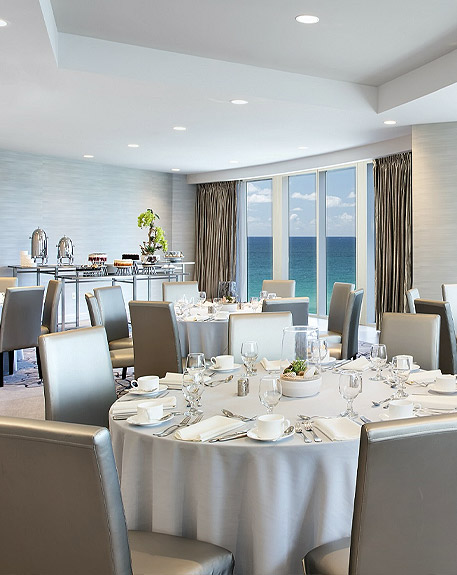  a room set up for dining overlooking the beach