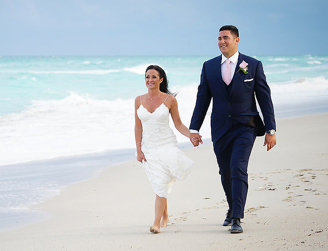 bride and groom walking along the beach together