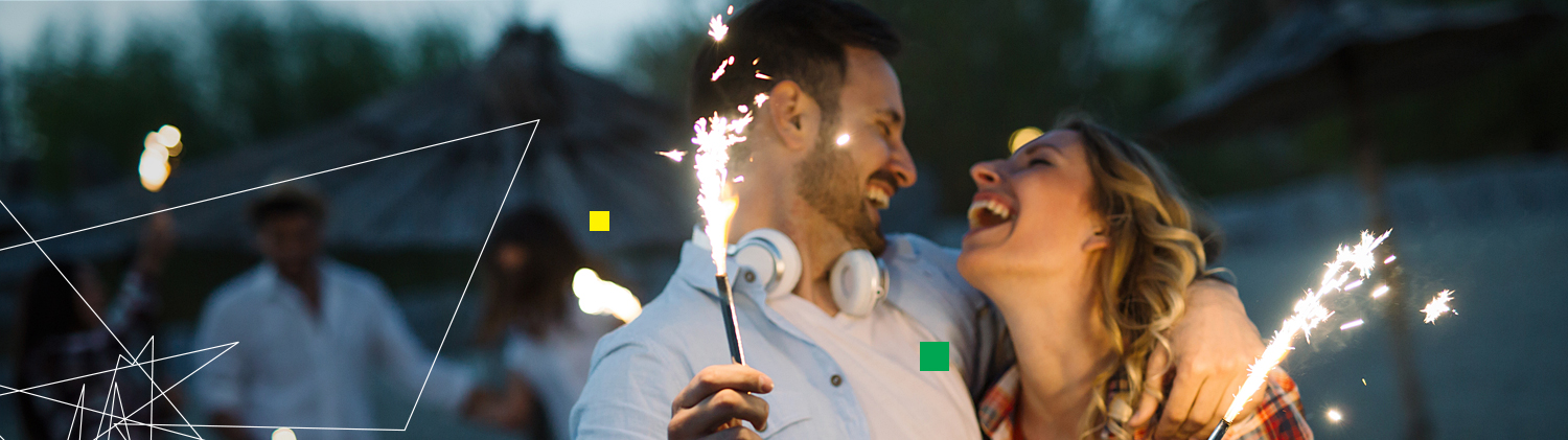 Couple laughing with sparklers in hand
