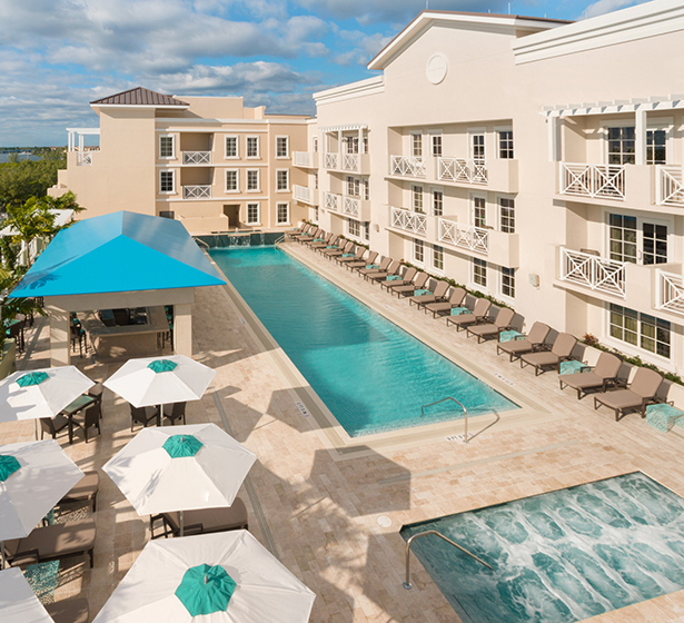 swimming pool area with white and teal umbrellas